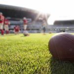 American football on a grass field at a stadium