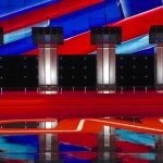 Mike Rogers Ends Abdul El-Sayed at Michigan Debate Over and OVER Again Debate stage with four empty podiums and bright red and blue backdrop