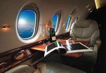 private jet cabin with leather seat, champagne and magazine on table