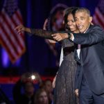 Michelle Obama and Rob Nabors pointing on stage at an event
