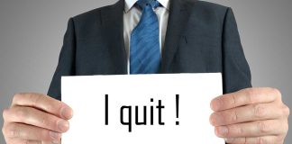 Person holding a sign saying "I quit!"