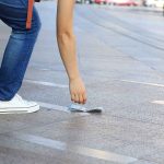 Person picking up money from the ground.