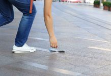 Person picking up money from the ground.