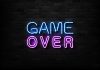 game over neon sign on brick wall.