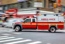 Ambulance speeding through city street intersection.