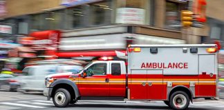 Ambulance speeding through city street intersection.