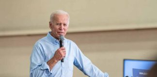 Man speaking into microphone at event podium indoors