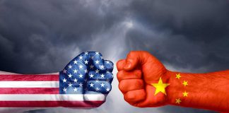 Fists painted like USA and China flags facing off