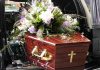 Coffin with flower arrangement in a hearse.