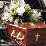 Coffin with flower arrangement in a hearse.