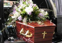 Coffin with flower arrangement in a hearse.