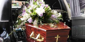 Coffin with flower arrangement in a hearse.