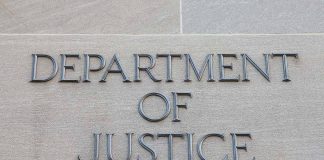 Department of Justice sign on building wall.