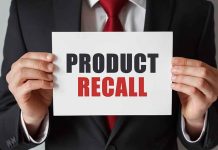 "Product Recall" sign held by person in suit.