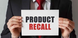 "Product Recall" sign held by person in suit.