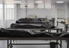 Covered bodies on metal tables in a morgue.