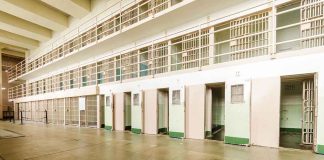 Empty prison cells with open doors, two-story layout.