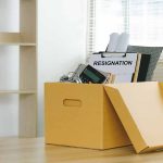 Yellow box with resignation notice on an office desk.