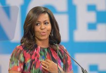 Woman speaking at podium with blue background.