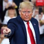 Man in suit pointing at rally audience