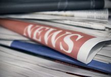 Stack of newspapers with "NEWS" headline visible.