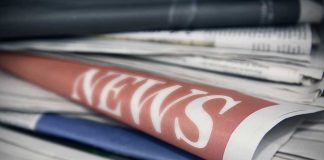 Stack of newspapers with "NEWS" headline visible.