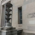 Department of Justice building with sculpture outside.