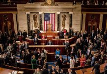 Crowded legislative chamber with people in discussion