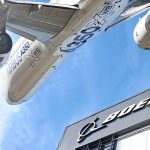 Airbus plane flying over Boeing building