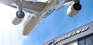 Airbus plane flying over Boeing building