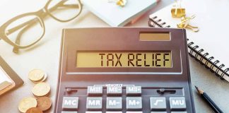 Calculator display reads TAX RELIEF amidst coins and glasses