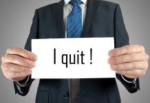 Person holding a sign saying I quit!