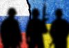 Silhouettes in front of Russian and Ukrainian flags