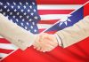 Two people shaking hands with USA Taiwan flags