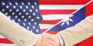 Two people shaking hands with USA Taiwan flags