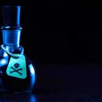 Dark bottle with skull and crossbones label on table