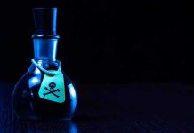 Dark bottle with skull and crossbones label on table