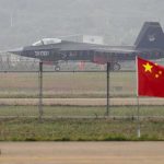 Jet with 31001 marking behind barbed wire fence