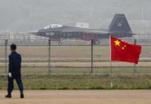 Jet with 31001 marking behind barbed wire fence