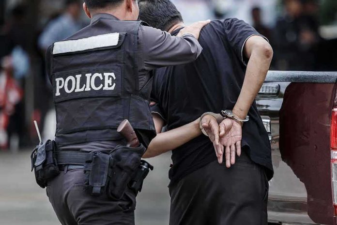 Police officer arrests handcuffed person