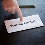 Envelope with YOU RE FIRED and pointing finger