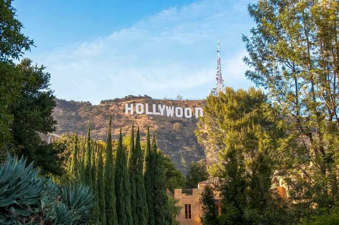 1164563563 Hollywood sign on hill surrounded by trees and buildings