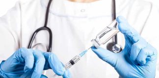 Doctor filling syringe with vaccine from vial