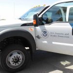 U.S. Customs and Border Protection truck with open door.