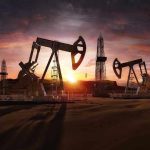 Oil rigs operating at sunset in a desert landscape