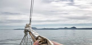 Sailboat bow facing calm sea and distant mountains