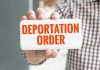 Hand holding sign with Deportation Order Text