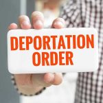 Hand holding sign with Deportation Order Text