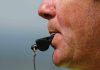 Close up of a sports coach blowing a whistle