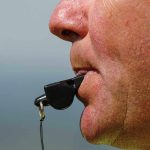 Close up of a sports coach blowing a whistle